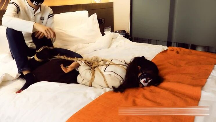 Девушка с двумя косичками в бондаже и с кляпом во рту.